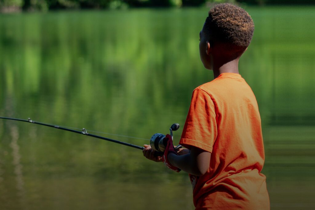 Boy in orange shirt fishing