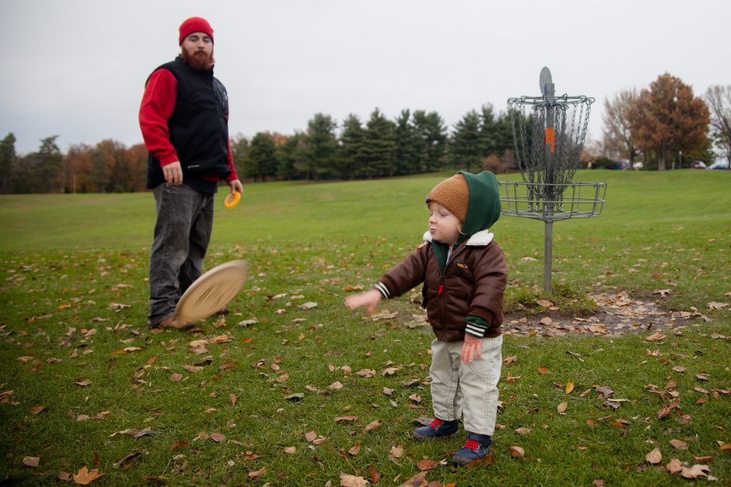 father and child playing disc golf